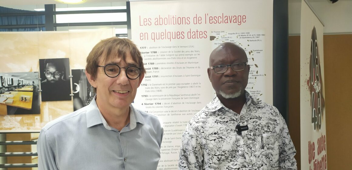 Le directeur des archives départementales de Guadeloupe, Benoît Jullien (à gauche, accueille le 29 mai 2024 Bertin Calixte Biah (à droite), directeur du musée d’histoire de Ouidah au Bénin, lors d'une visite des archives à Bisdary, Gourbeyre. Photo : X Véronique Parmentier DR Le directeur des archives départementales de Guadeloupe, Benoît Jullien (à gauche, accueille le 29 mai 2024 Bertin Calixte Biah (à droite), directeur du musée d’histoire de Ouidah au Bénin, lors d'une visite des archives à Bisdary, Gourbeyre. Photo : X Véronique Parmentier DR