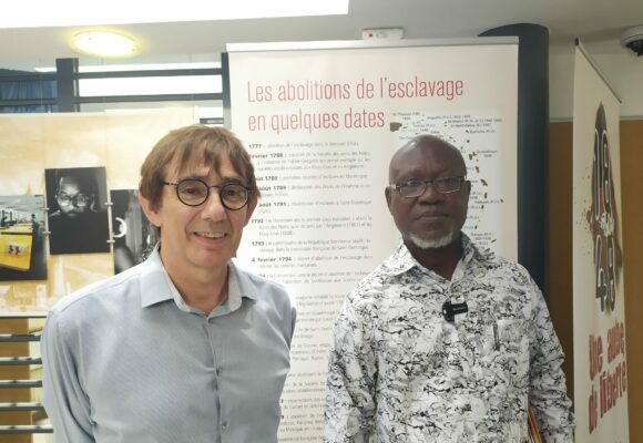 Le directeur des archives départementales de Guadeloupe, Benoît Jullien (à gauche, accueille le 29 mai 2024 Bertin Calixte Biah (à droite), directeur du musée d’histoire de Ouidah au Bénin, lors d'une visite des archives à Bisdary, Gourbeyre. Photo : X Véronique Parmentier DR