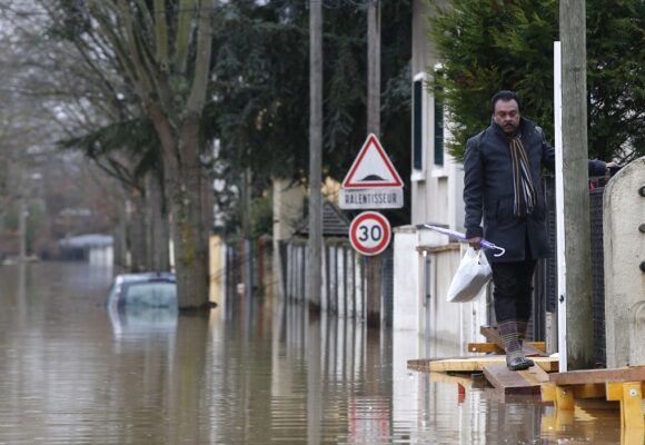 Un habitant marche sur une passerelle dans une rue inondée de Villeneuve-Saint-Georges, près de Paris, où l'Yerres est entrée en crue jeudi 25 janvier 2018. Photo AP/Thibault Camus